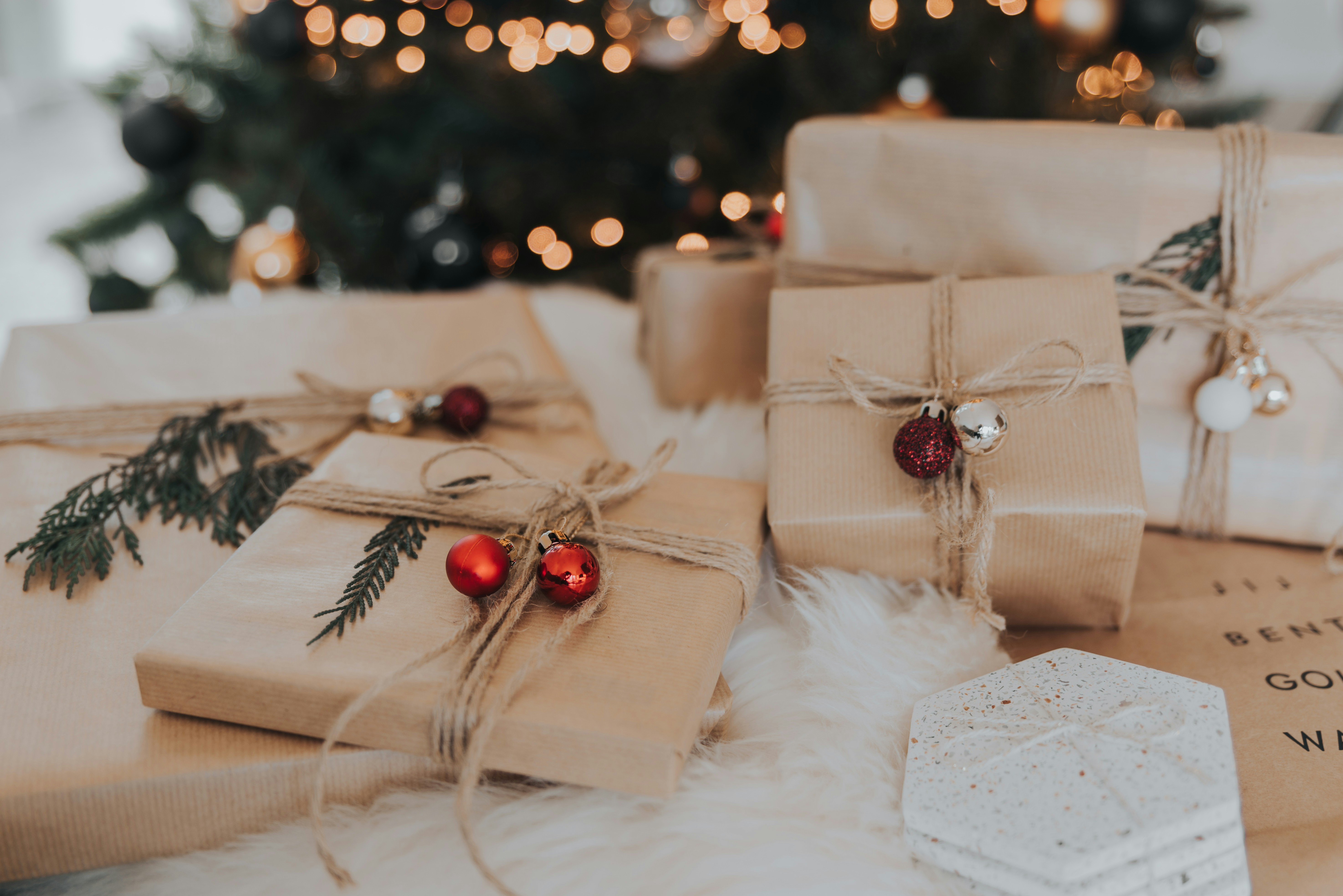 Weihnachtlich dekorierter Tisch mit handgemachten Geschenken: Keramiksterne, gestrickte Socken, Duftkerzen, Holzspielzeug und personalisierte Schmuckstücke